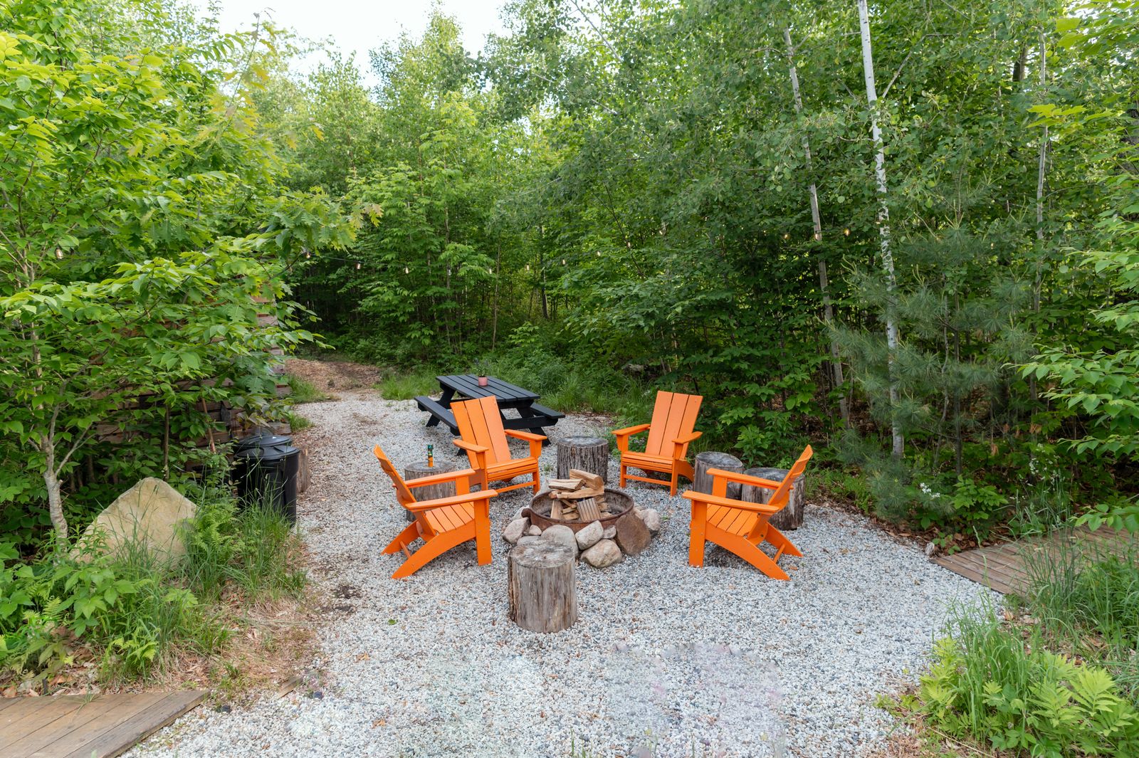 Adirondack chairs around a backyard fire pit