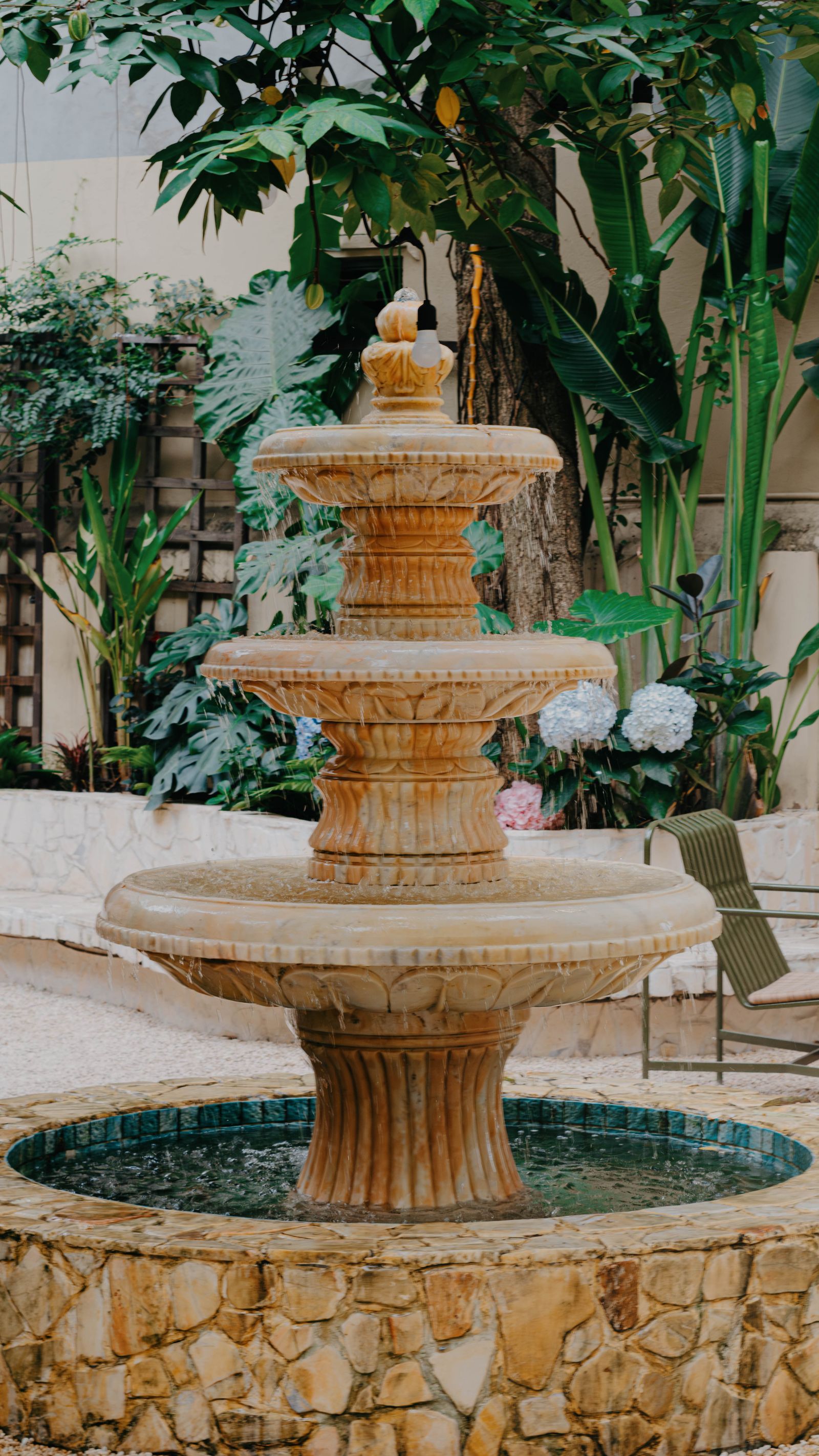 Tiered stone fountain surrounded by greenery