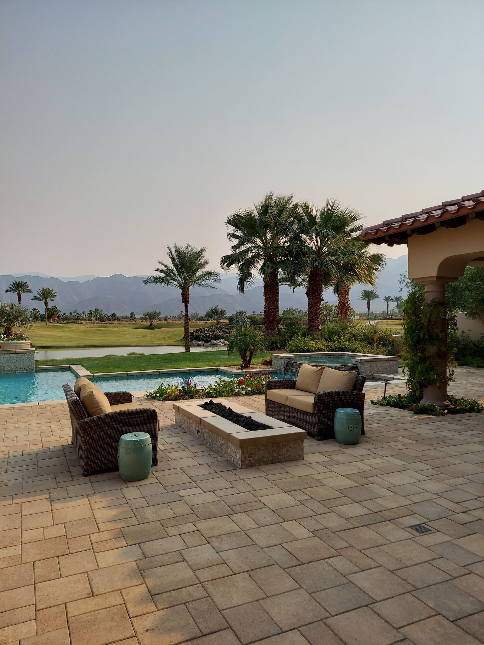 Patio with wicker seating beside a pool
