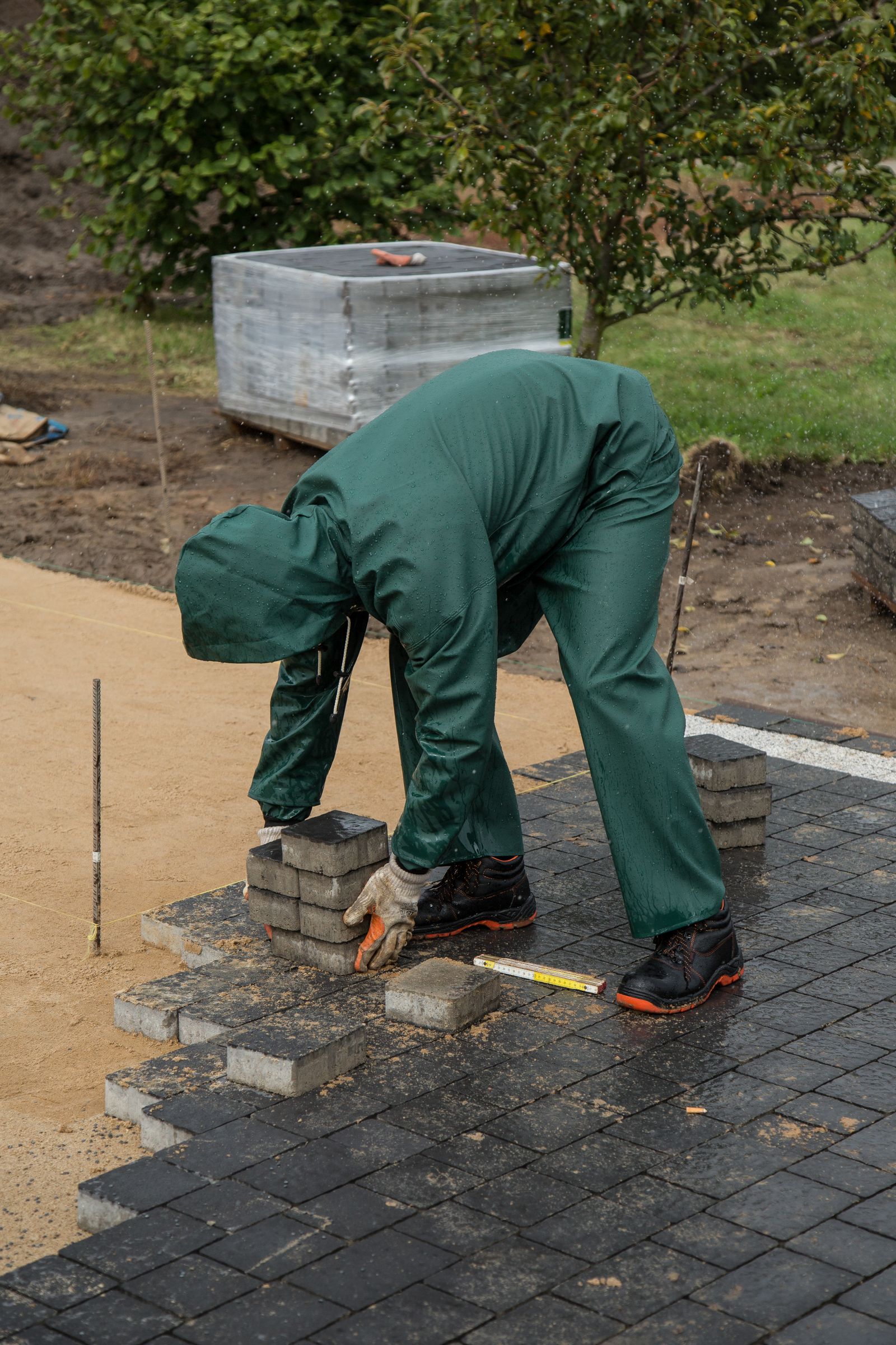 Crew installing paving stones during construction