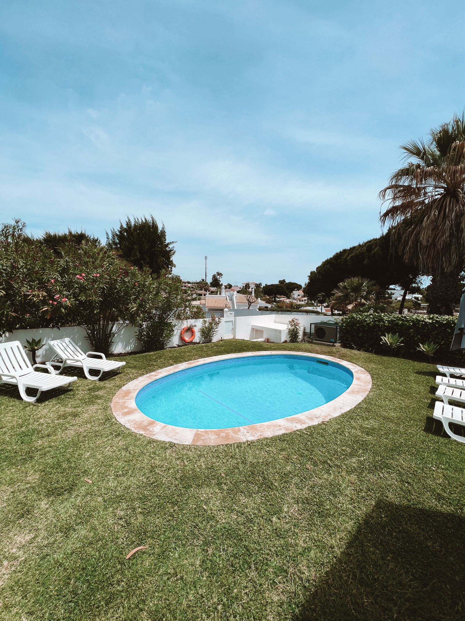 Oval pool with lounge chairs