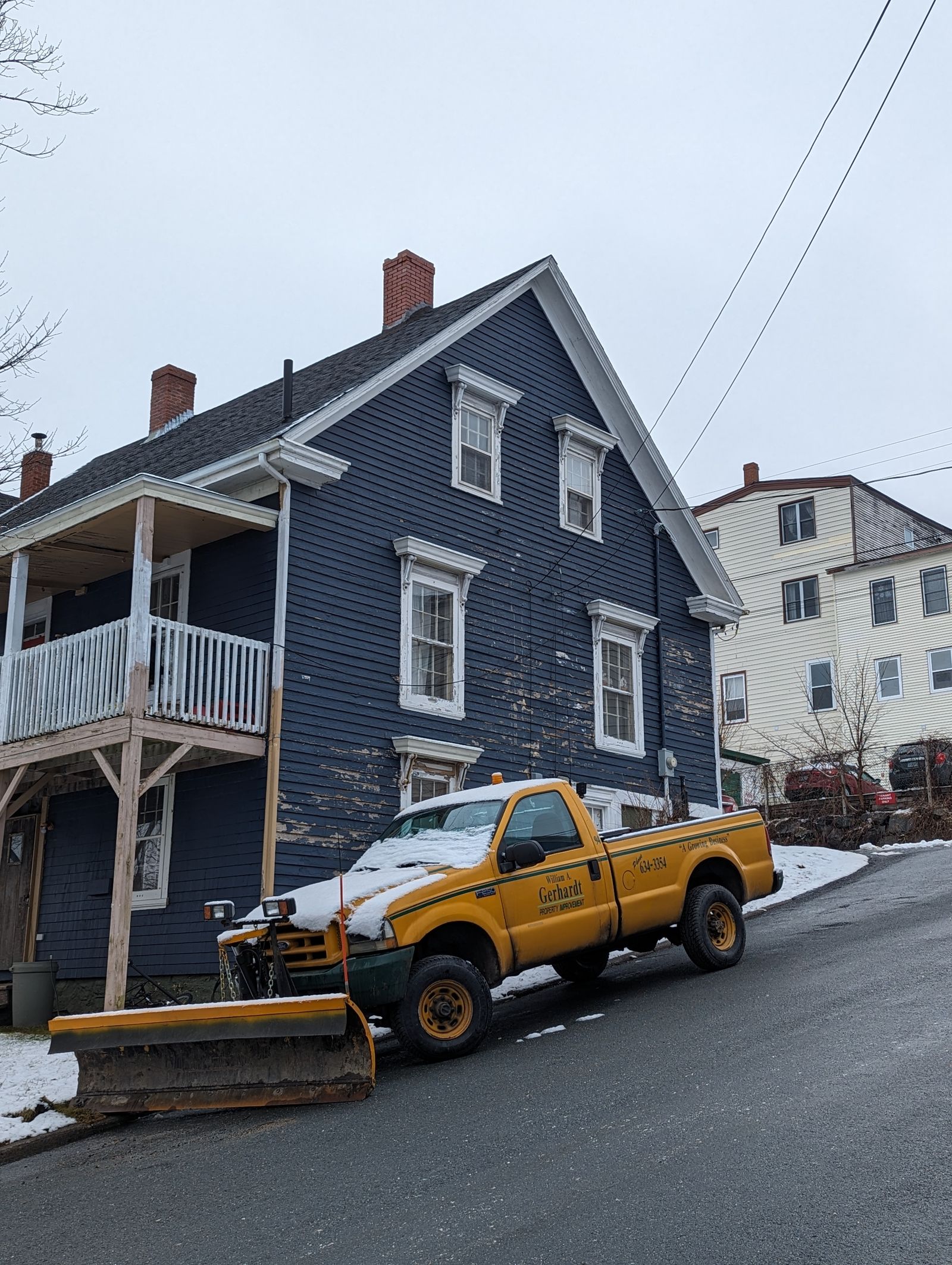 Pickup truck with plow clearing a snowy street