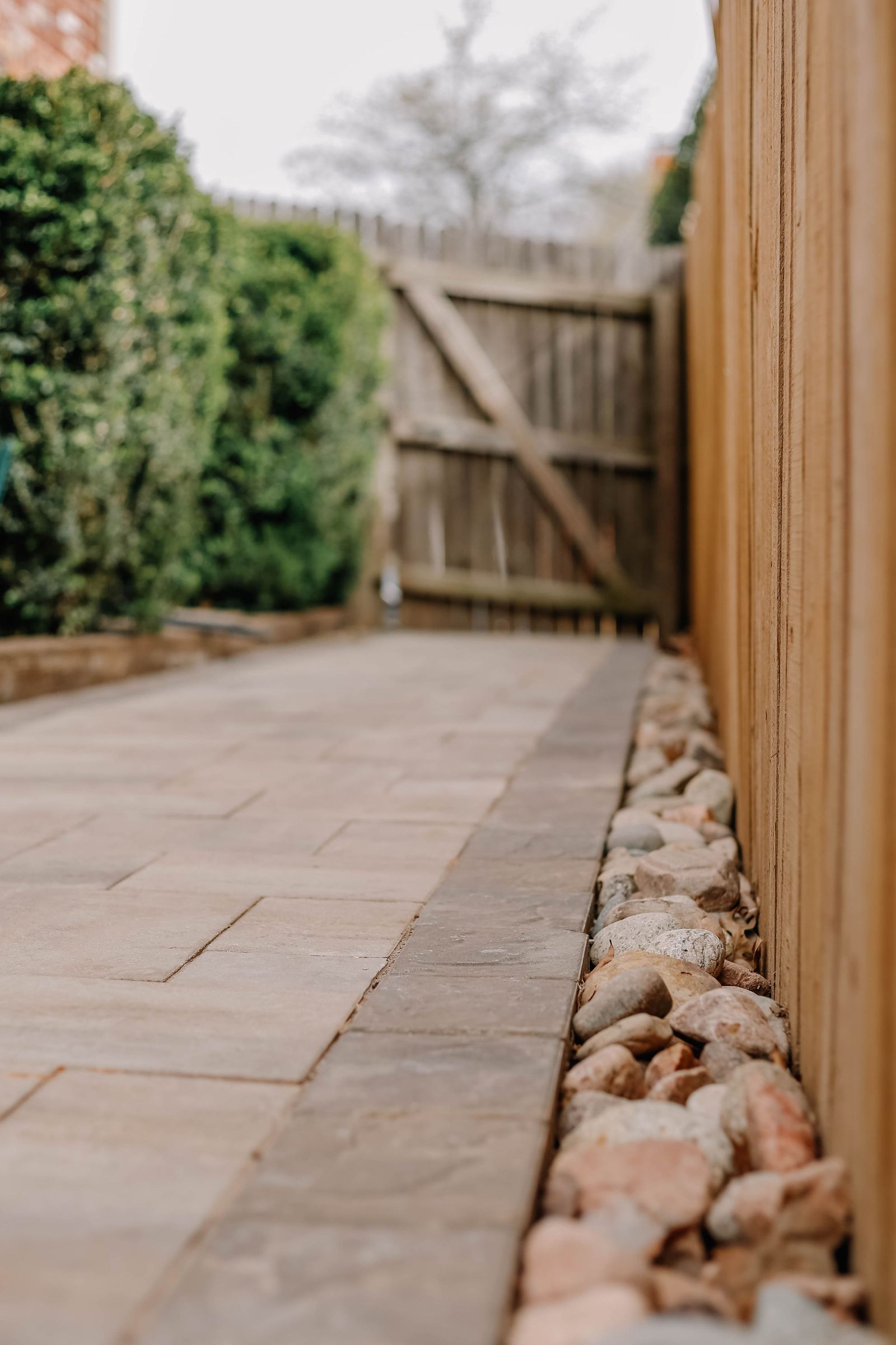 Paved stone pathway along a cedar fence