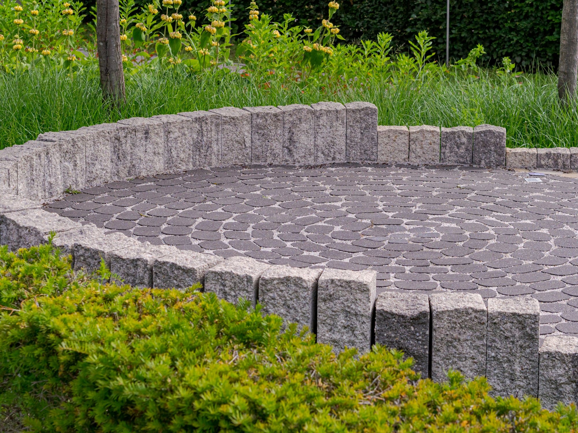 Circular paved patio edged with a low stone wall
